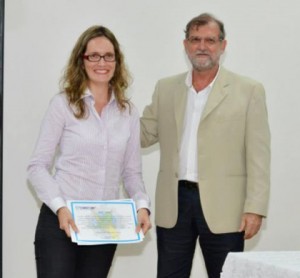 Professora Andrea, coordenadora do Colegiado, recebendo o prêmio pela melhor monografia da área na Bahia